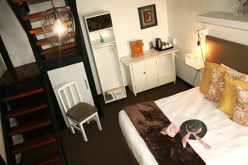 a hotel room with a bed and a staircase at The Residence at Villa Wiese in Swakopmund