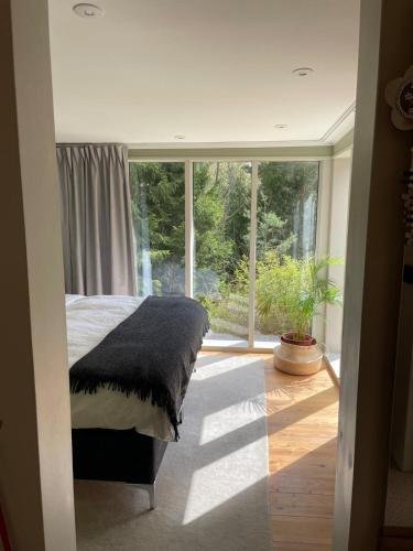 a bedroom with a bed and a large window at The Little Red in Västerhaninge