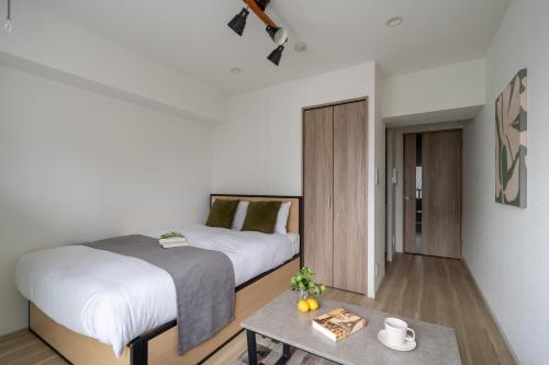 a bedroom with a large bed and a table at GRO-BEL THE KLES Kamata in Tokyo