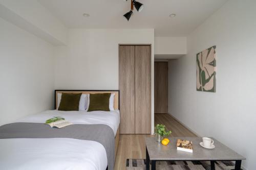 a bedroom with two beds and a table with a coffee table at GRO-BEL THE KLES Kamata in Tokyo