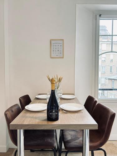 - une table à manger avec une bouteille de vin dans l'établissement Jadart T3 avec balcon au pied de la cathédrale, à Reims