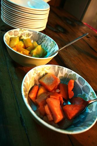 two bowls of carrots and fruit on a wooden table at The Residence at Villa Wiese in Swakopmund