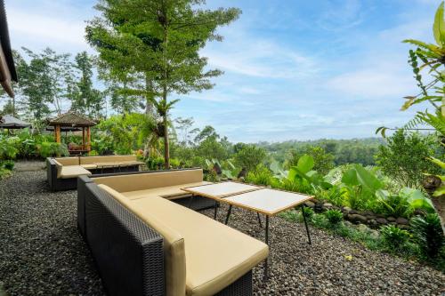 an outdoor patio with tables and benches and a view at Angseri Villas in Tabanan