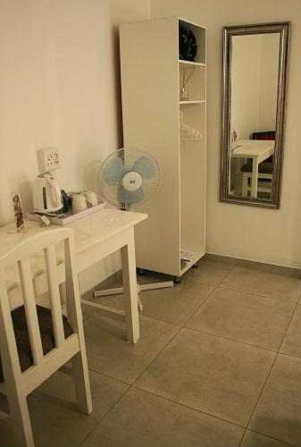 a room with a table with a fan and a mirror at The Residence at Villa Wiese in Swakopmund
