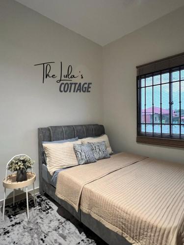 a bedroom with a bed and a sign that reads the kids conference at The LuLas Cottage in Malacca