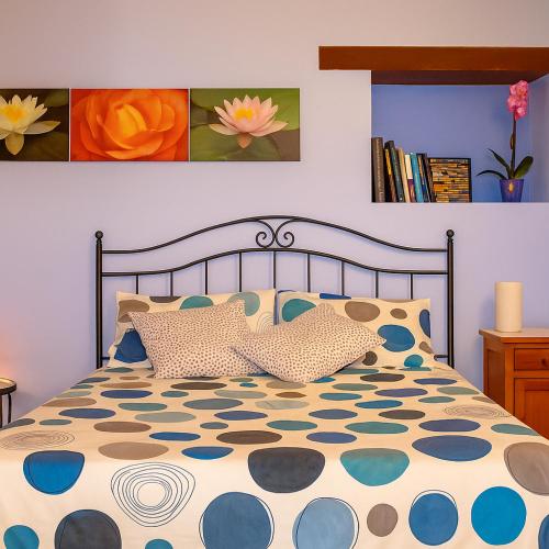a bedroom with a bed with a blue and white comforter at Casa il Girasole con piscina nelle Marche in Macerata