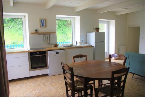 une cuisine avec une table en bois et un réfrigérateur dans l'établissement L'abri du guindy, à Plouguiel