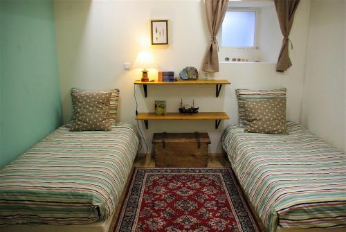 - 2 lits dans une petite chambre avec une table dans l'établissement L'abri du guindy, à Plouguiel
