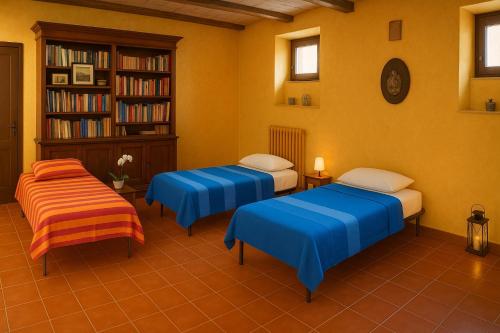 a room with two beds and a book shelf at Casa il Girasole con piscina nelle Marche in Macerata