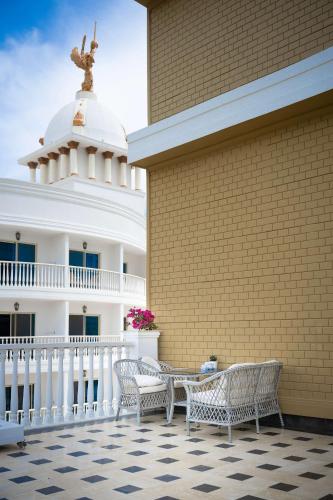 a patio with two chairs and a building with a statue at Oz Hotels Sui in Alanya