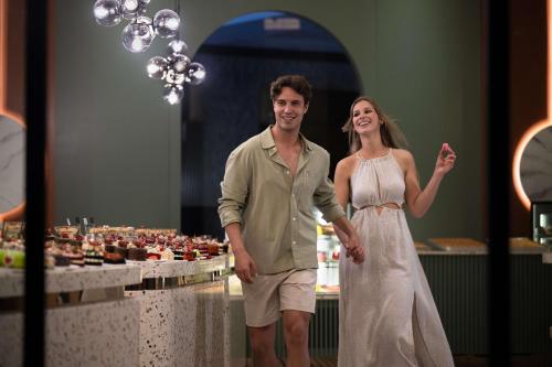 a man and a woman standing in front of a buffet at Oz Hotels Sui in Alanya
