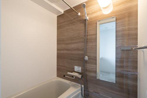 a bathroom with a bath tub and a mirror at GRO-BEL THE KLES Kamata in Tokyo