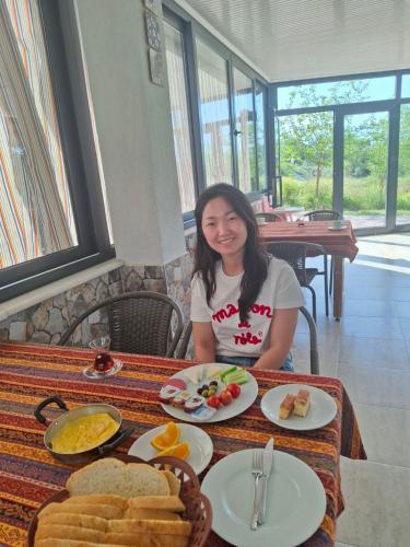 a woman sitting at a table with food on it at Paradise House in Pamukkale