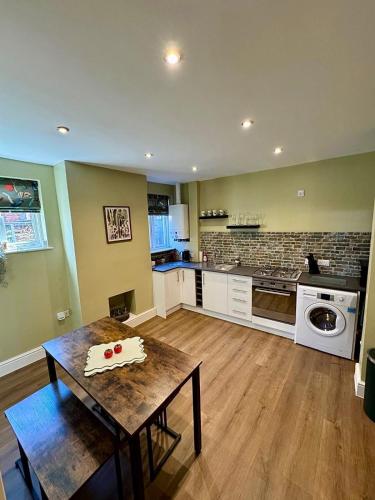 a living room with a table and a kitchen at Quaint Bury St Edmunds Cottage in Bury Saint Edmunds