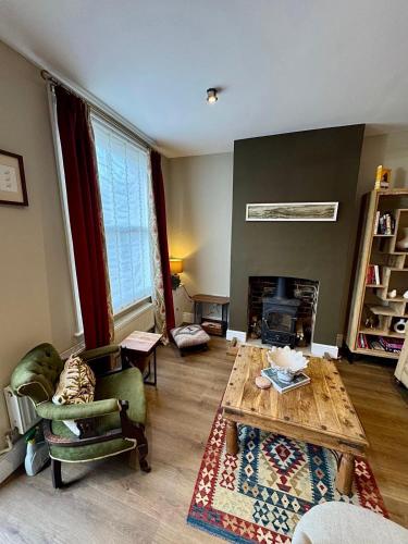 a living room with a coffee table and a fireplace at Quaint Bury St Edmunds Cottage in Bury Saint Edmunds