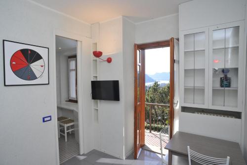 a room with a door to a balcony with a clock at La Finestra Sul Lago in Cernobbio