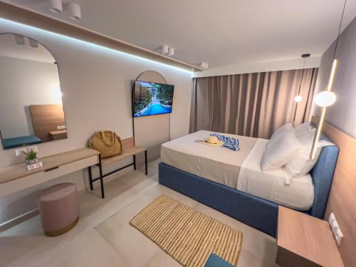 a bedroom with a bed and a desk and a mirror at Luxury Rooms Naoum - Adults only in Limenaria