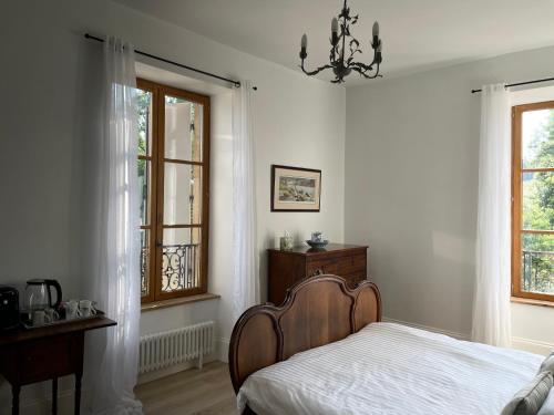 a bedroom with a bed and a dresser and windows at Cantaranne in Privezac