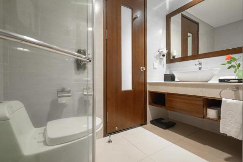 une salle de bain avec un lavabo, des toilettes et une douche dans l'établissement Grand Tourane Hotel Da Nang, à Đà Nẵng