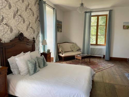 a bedroom with a bed and a chair and a window at Cantaranne in Privezac