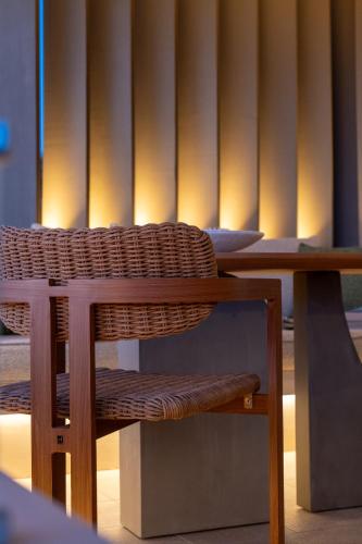 a wicker chair sitting at a table in a room at Artblue Villas in Tsoukaladhes