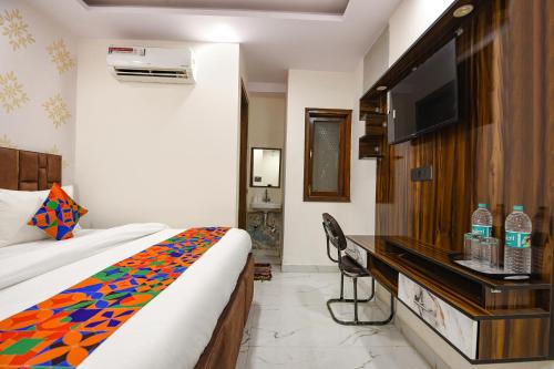 a hotel room with a bed and a flat screen tv at FabHotel NP International - Nehru Place Market in Jāmb