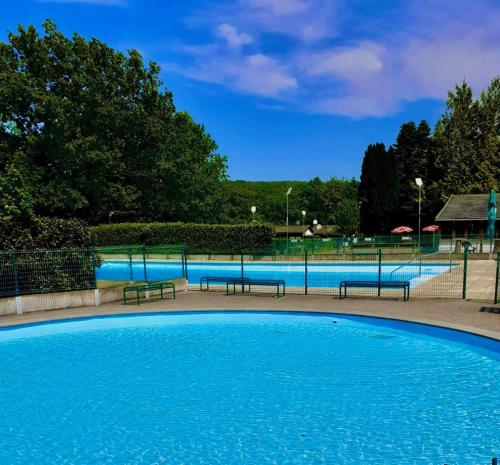 a large swimming pool with benches in a park at Chalet 5 personnes avec piscine in Yvoir