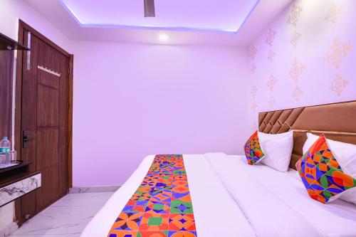 a bedroom with a bed with a colorful comforter at FabHotel NP International - Nehru Place Market in Jāmb