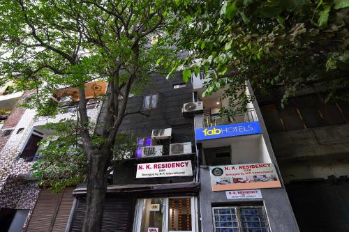 a building with a tree in front of it at FabHotel NP International - Nehru Place Market in Jāmb