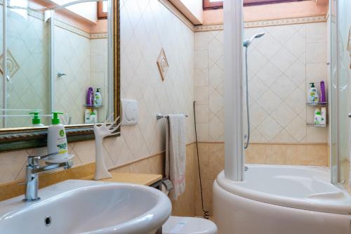 a bathroom with a sink and a toilet and a mirror at Casa Graziella the top holiday home in Ugento
