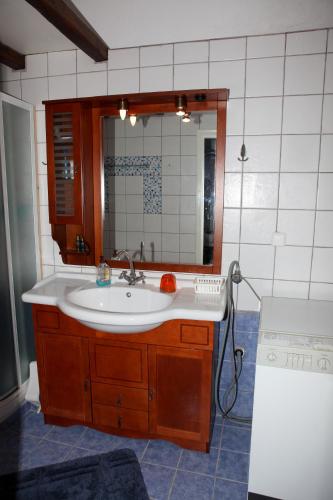 ein Badezimmer mit Waschbecken und Spiegel in der Unterkunft Sunset House in Klíma