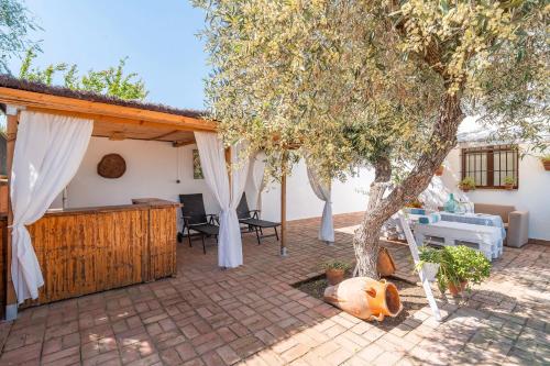 a patio with a tree and a house at Casa Rural Pozo Viejo in Marchena