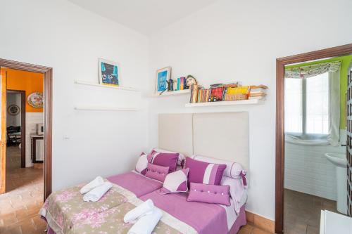 a bedroom with a purple bed and a window at Casa Rural Pozo Viejo in Marchena
