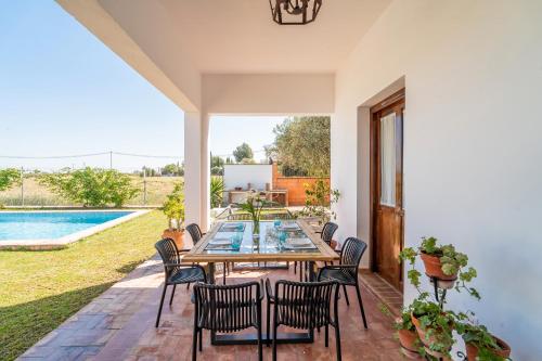 a patio with a table and chairs and a pool at Casa Rural Pozo Viejo in Marchena
