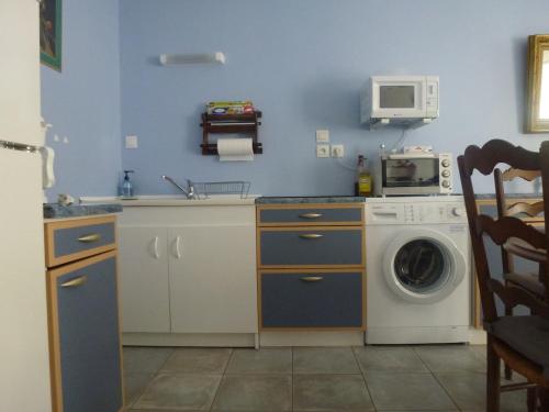 a kitchen with a washing machine and a microwave at Maison au calme in Rochefort