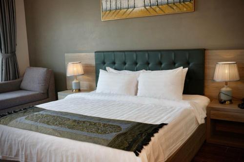 a bedroom with a large bed with a green headboard at KEP BAY HOTEL & RESORT in Kep