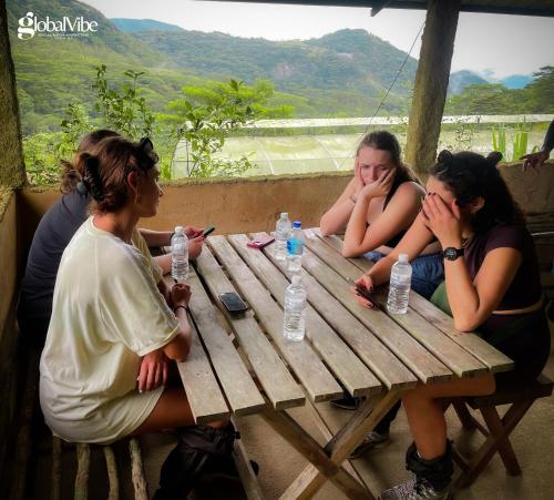 three women sitting at a picnic table with water bottles at Royal Mountain Edge ,Knuckles in Rangala