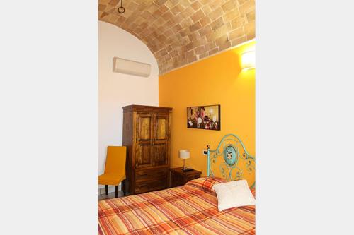 a bedroom with a bed and an orange wall at La Casa Del Palombaro in Ortona