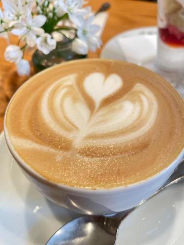 a cup of coffee with a heart painted on it at Kamakura Jomyoji Terrace-鎌倉浄明寺テラス- in Kamakura