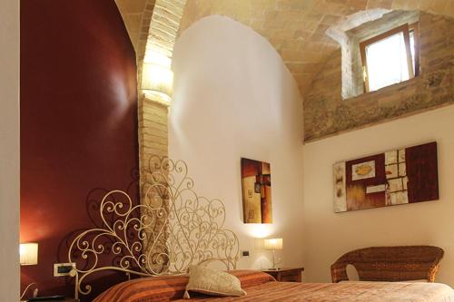 a bedroom with a bed with a wooden head board at La Casa Del Palombaro in Ortona