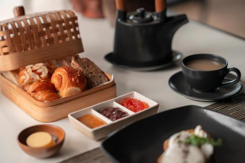 a table with a tray of pastries and a cup of coffee at Soori Bali in Tabanan