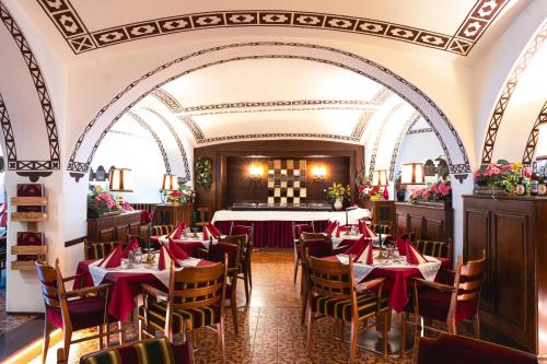 a dining room with tables and chairs with red napkins at Hotel Rossmann in Greifenburg