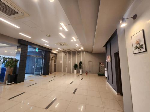 an office lobby with a large hallway with potted plants at Jeju BnB Hotel in Jeju