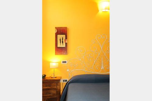 a bedroom with a bed and a yellow wall at La Casa Del Palombaro in Ortona