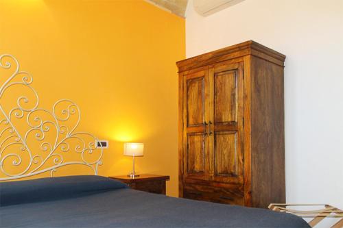 a bedroom with a bed and a wooden cabinet at La Casa Del Palombaro in Ortona