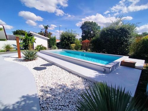 une piscine dans un jardin avec un banc dans l'établissement Maison 4 personnes avec piscine et espace bien-être partagés, à Brach