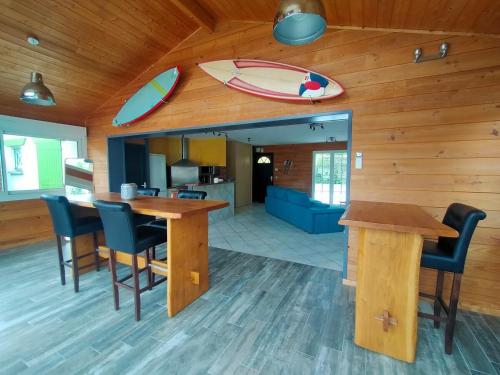 une cuisine avec une table et des chaises ainsi qu'une planche de surf murale dans l'établissement Maison 4 personnes avec piscine et espace bien-être partagés, à Brach
