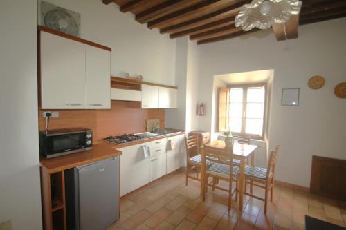 a kitchen with a table and chairs and a microwave at Lo Scricciolo in Montecastelli Pisano