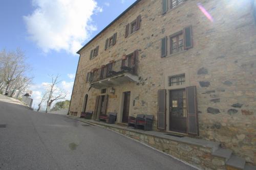 an old stone building with a balcony on a street at Lo Scricciolo in Montecastelli Pisano