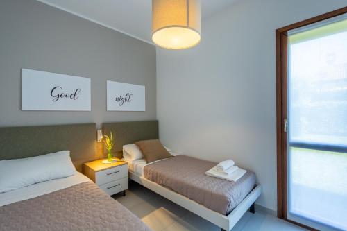 a bedroom with two beds and a window at Isola di Albarella in Isola Albarella